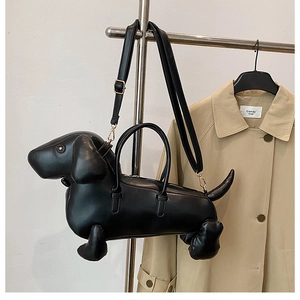 Detail of dachshund-shaped handbag with adjustable shoulder straps and gold metal hardware