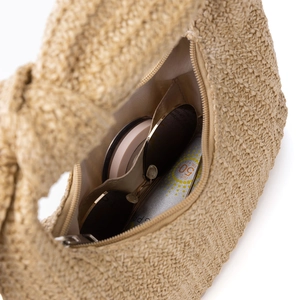 Top view of straw handbag interior showing spacious storage for sunglasses and cosmetics