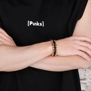Détail d'un bracelet homme style punk en acier inoxydable et caoutchouc sur le poignet