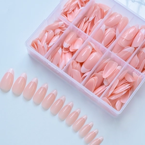 Detail view of pink almond press-on nails with white French tips in a clear storage box
