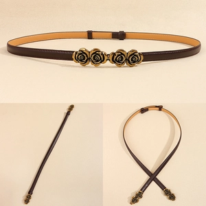 Detail view of a thin dark brown leather belt with elegant golden rose flower buckle