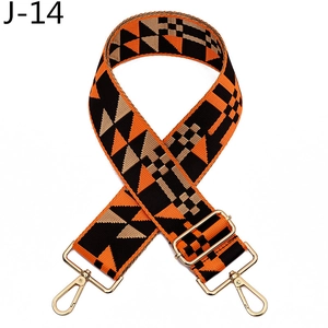 Macro detail of wide woven shoulder strap with geometric orange pattern and gold hooks