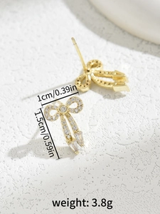 Detail showing dimensions and weight of golden bow earrings with zircon stones