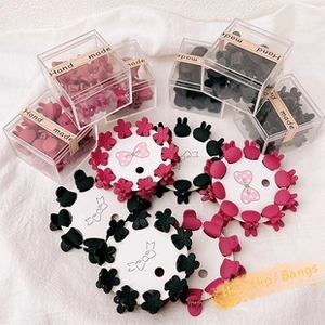 Close-up of matte flower and bunny mini hair clips in pink and black gift boxes