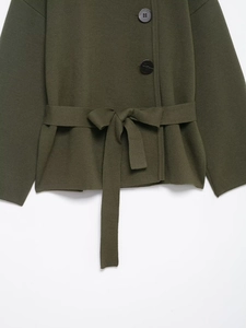 Detailansicht der dunkelgrünen Strickjacke mit Bindegürtel und schwarzen Rundknöpfen