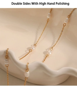 Macro detail of high polished gold stainless steel chain with natural white pearls