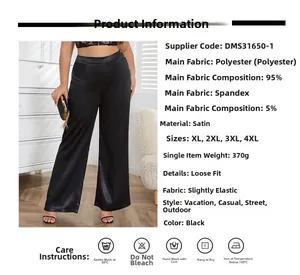 Détail du tissu satiné noir lisse et de la coupe large taille haute de ce pantalon fluide