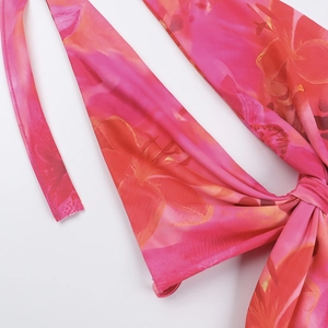 Vue détaillée du nœud frontal sur une robe de plage courte à imprimé floral rose et orange