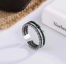 Detailed macro of S925 sterling silver ring with green stones and woven texture