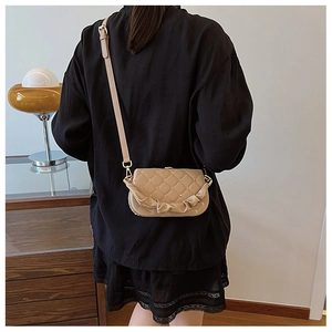 Detailed back view of a beige quilted crossbody bag with pleated handle and chain strap