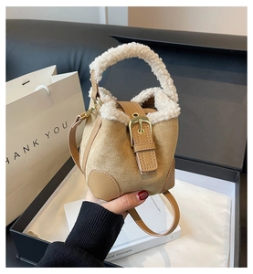 Detail showing plush sherpa trim and khaki suede finish on mini bucket crossbody bag