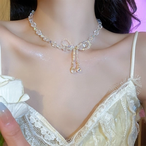 Close-up of sparkling crystal butterfly necklace with teardrop pendants on model's neck