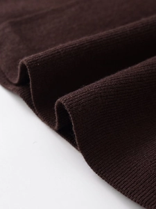 Dettaglio macro del tessuto a maglia a coste marrone scuro con trama verticale