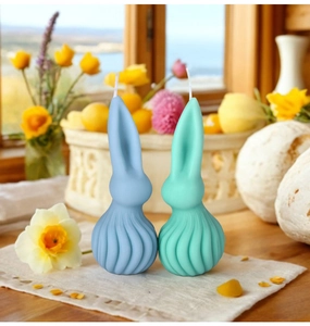 Zwei Hasen-Duftkerzen mit Spiralstruktur in Blau und Minzgrün für die Osterdeko