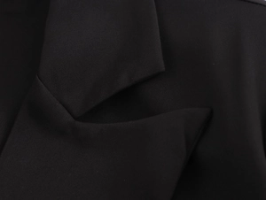Macro shot of black blazer collar showing premium fabric texture and shoulder tailoring