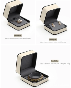 Detailed view of luxury beige leather jewelry gift boxes with gray velvet interior slots
