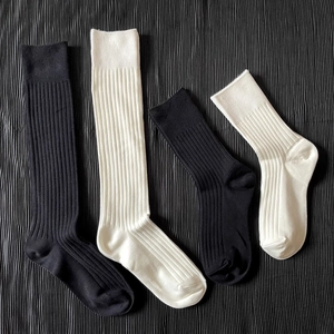 Detailed view of black and white ribbed knit knee-high socks in various lengths
