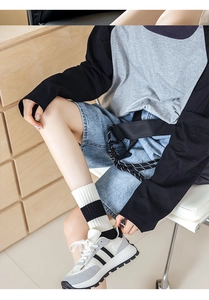 Detailed look at striped crew socks styled with denim shorts and casual sneakers
