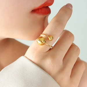 Bague ouverte ajustable dorée minimaliste avec sphères en métal poli sur un mannequin