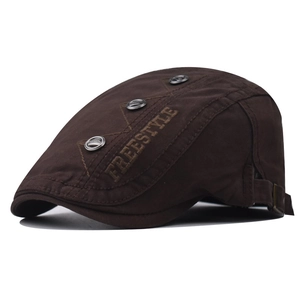 Detail of dark brown flat cap with FREESTYLE embroidery and decorative metal buttons