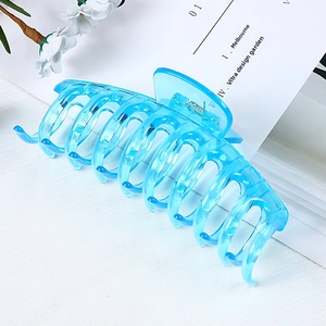 Detail shot of a large light blue transparent hair claw clip with a durable metal spring