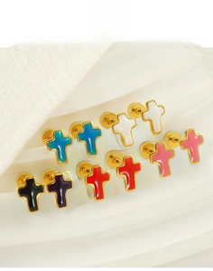 Macro detail of multicolored enamel cross earrings in vacuum plated titanium steel