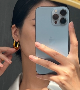 Close-up of geometric hoop earring with amber resin and 18k gold plating on model