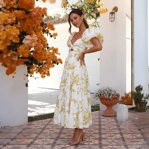 Close-up of white dress with yellow floral prints and puff sleeves in outdoor garden