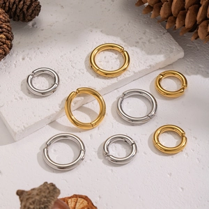 Minimalist 18K gold and silver stainless steel ear cuffs on white stone and pine cone
