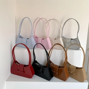 Elegant baguette shoulder bags with bow detail in various colors on a display stand