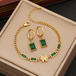 Golden butterfly necklace and earrings set with emerald green zircon in a gift box