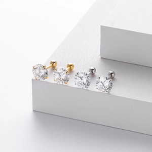 Detail view of silver and gold screw back stud earrings with sparkling cubic zirconia settings