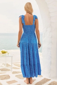 Detail of blue polka dot maxi dress with tiered skirt on a Mediterranean terrace