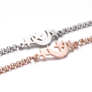 Detailed close-up of celestial star and moon pendants on delicate link chain bracelets