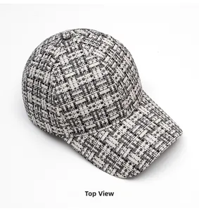 Top view of black and white tweed baseball cap with textured woven fabric finish