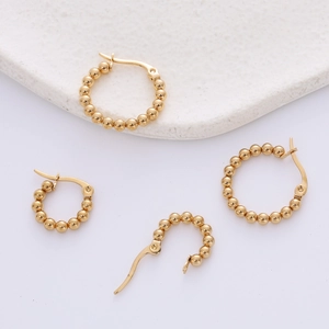 Detail of gold beaded hoop earrings showing various sizes and secure clasp closure