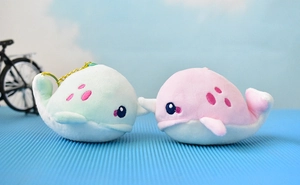 Detailed shot of cute pink and mint green plush narwhal keychains on a blue mat
