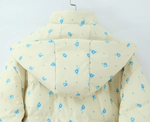Detail of floral hooded winter coat with blue flower pattern on beige fabric