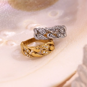 Close-up of gold and silver plated Cuban link rings with diamonds on a shell