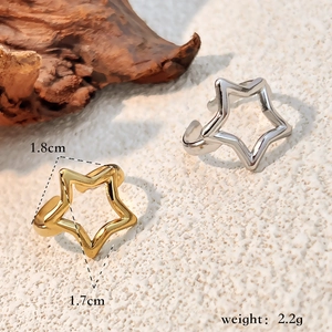 Minimalist gold and silver hollow star open rings on a natural wood display