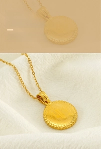 Macro shot of gold stainless steel St. Benedict medal pendant with a rope texture edge