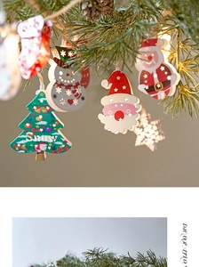 Detail of LED Christmas string lights with Santa and snowman wooden hanging ornaments