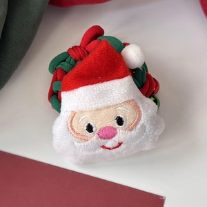 Détail d'un chouchou Père Noël brodé avec un cordon élastique rouge et vert