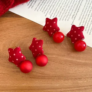 Red fabric star earrings set with polka dots and matte or glossy beads in festive style