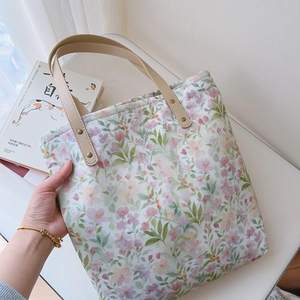 Close-up of floral cotton tote bag featuring synthetic leather straps and metal rivets