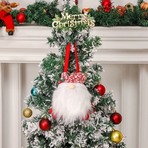 Christmas gnome ornament with plaid hat and white beard hanging on snowy tree branch