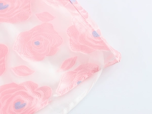 Detailed macro view of light pink floral jacquard fabric with rose pattern and embroidery