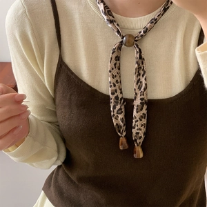 Detail view of leopard print fabric necklace with amber resin slider and cone pendant