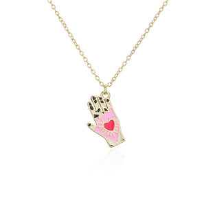 Detail of 18K gold-plated palm pendant with colorful enamel and red heart motif