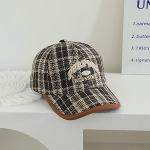 Detail of vintage plaid baseball cap with embroidered lettering and wool texture